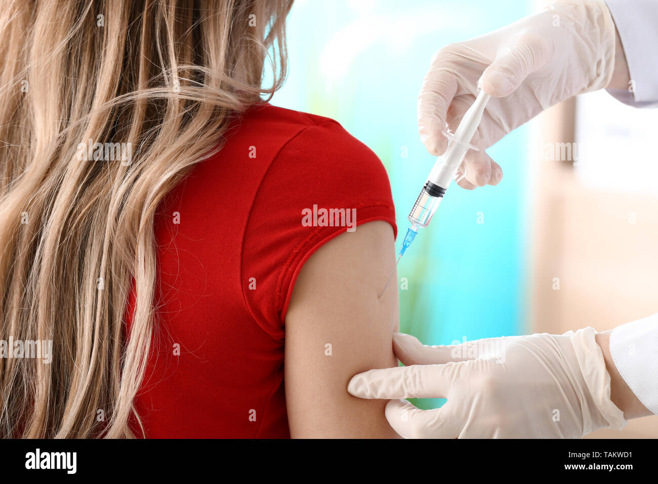 Doctor vaccinating woman against flu in clinic Stock Photo