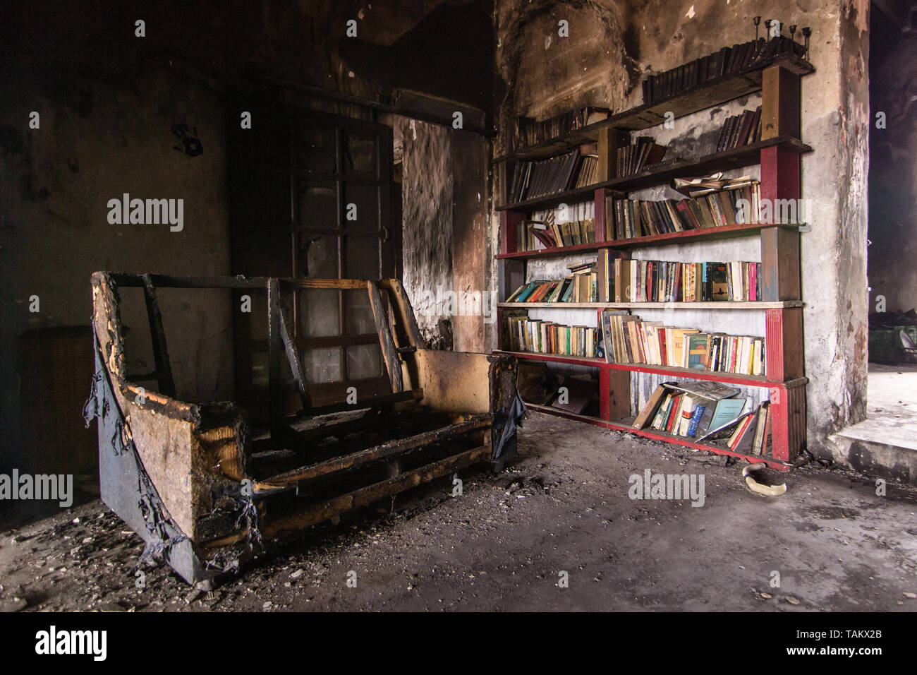 Sofa and book case burnt after a fire. Disaster, Ignorance, Brain Washing, Desolation Stock Photo