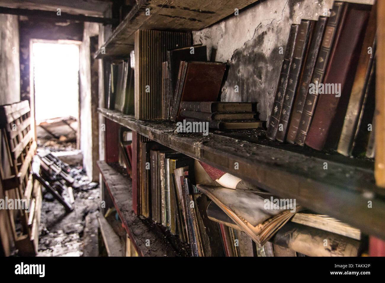 Book burnt in a bookcase after a fire.Disaster, Ignorance, Brain Washing, Desolation. Stock Photo