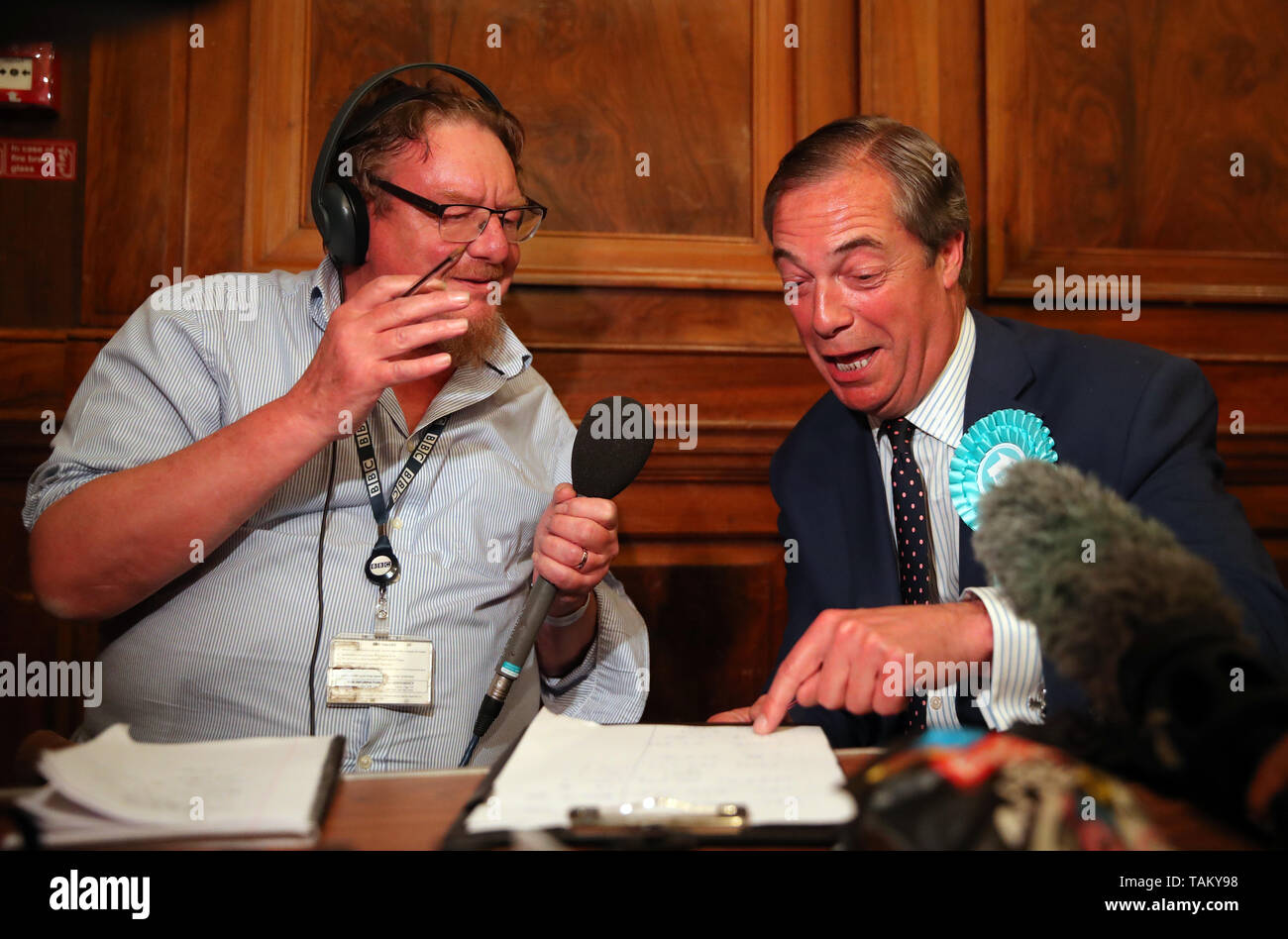 Brexit Party leader Nigel Farage (right) is interviewed on radio after the European Parliamentary elections count at the Guildhall in Southampton. Stock Photo
