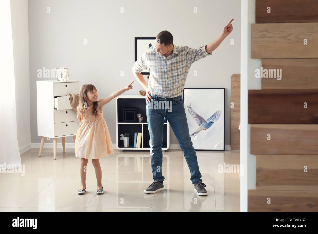 Father and his cute little daughter dancing at home Stock Photo