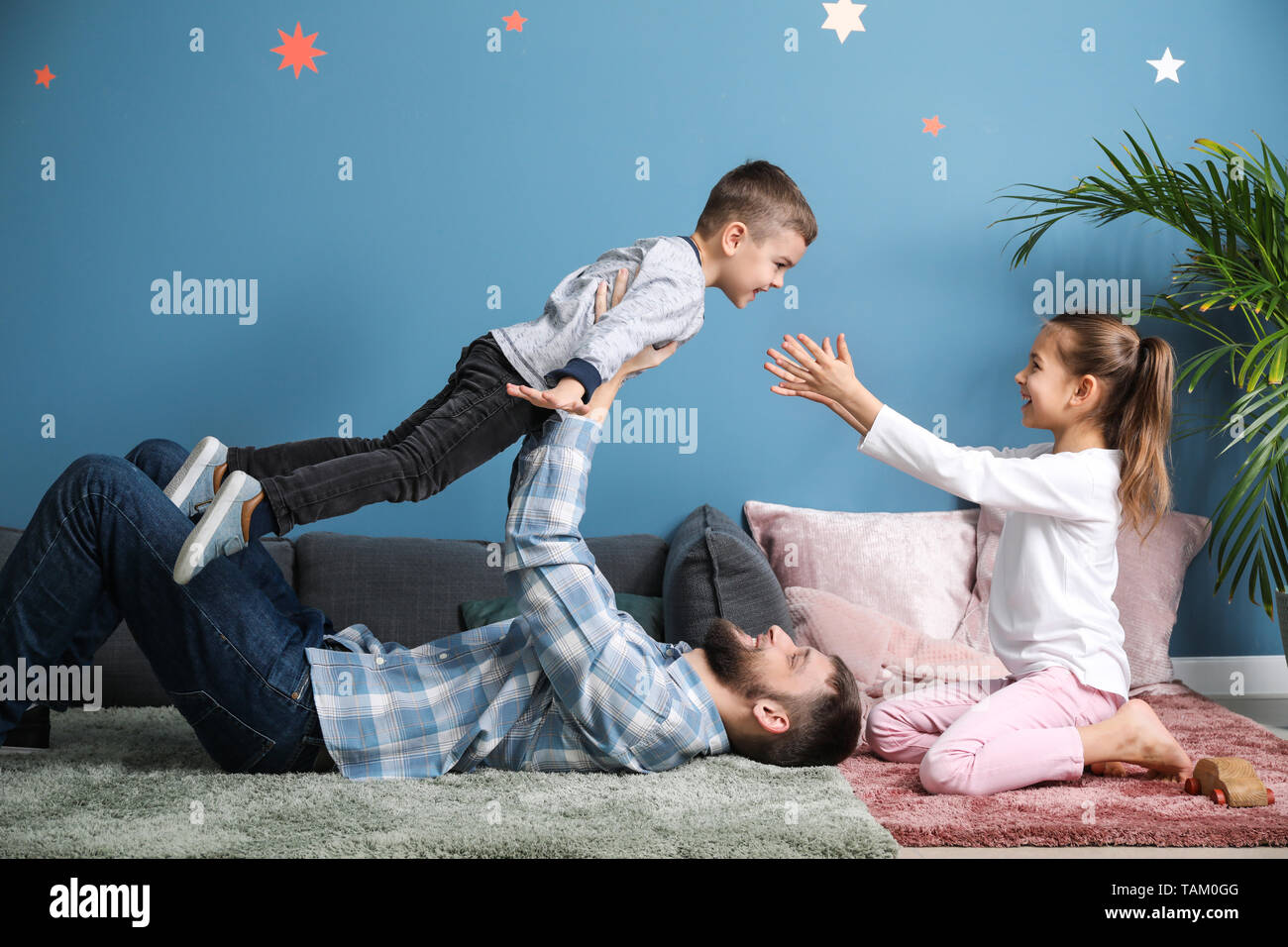 Young father with his children playing at home Stock Photo