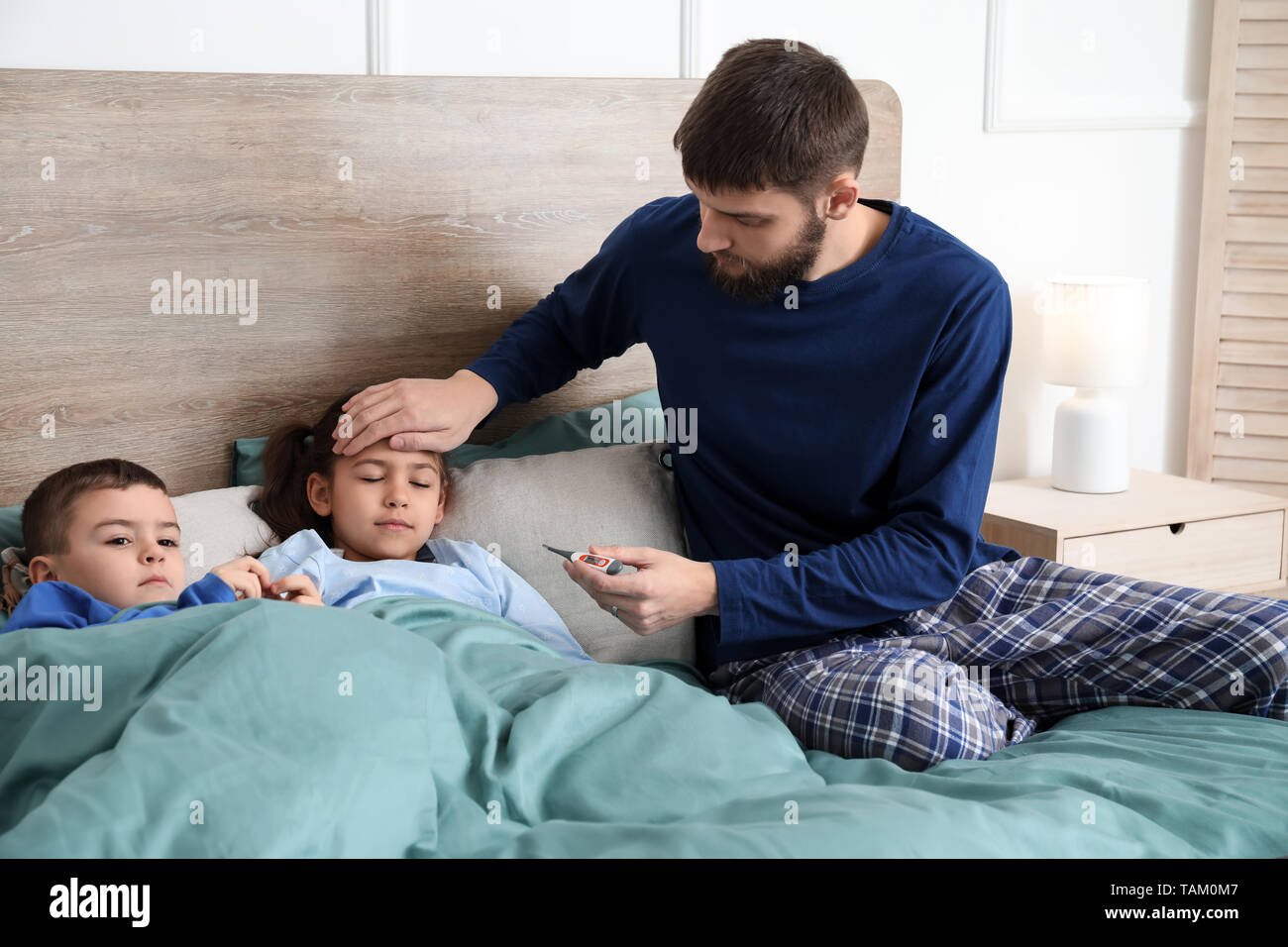 Young father taking care of sick children at home Stock Photo Alamy