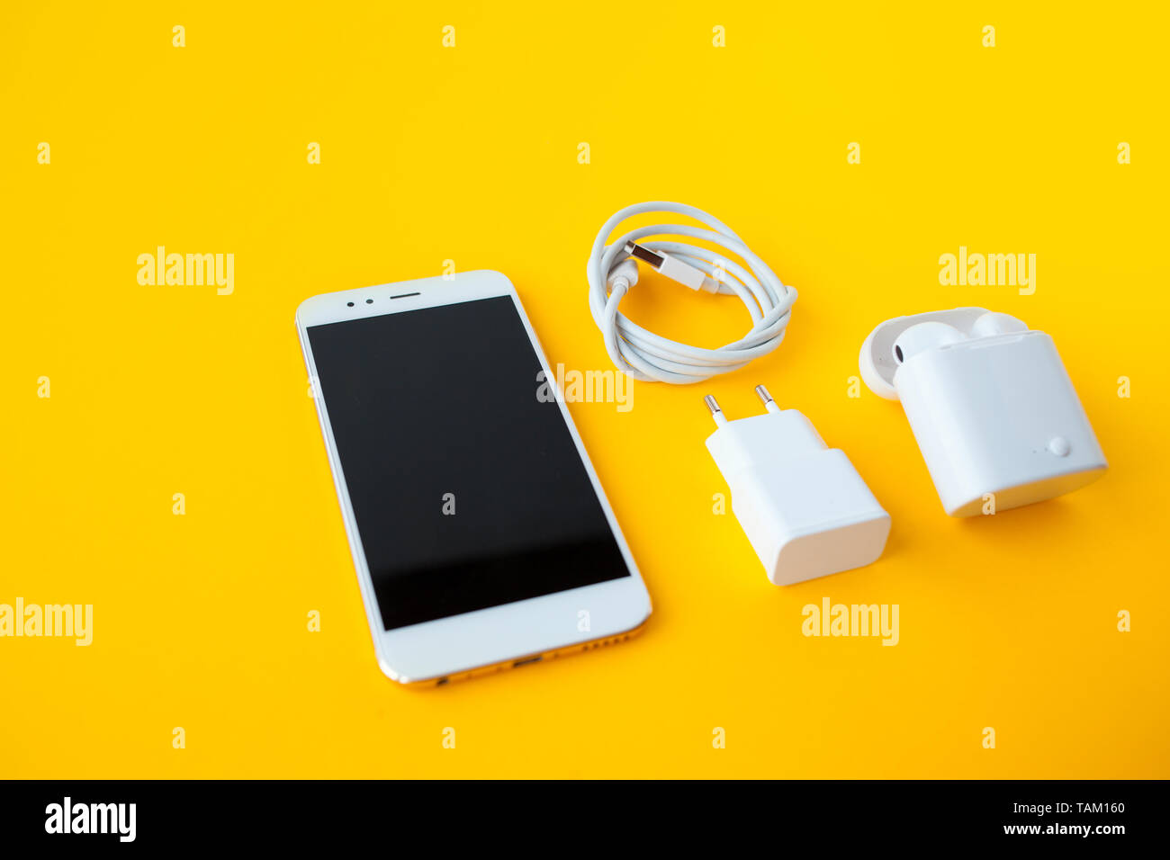 Mobile kit with smartphone, wireless headphones and chargers. Yellow