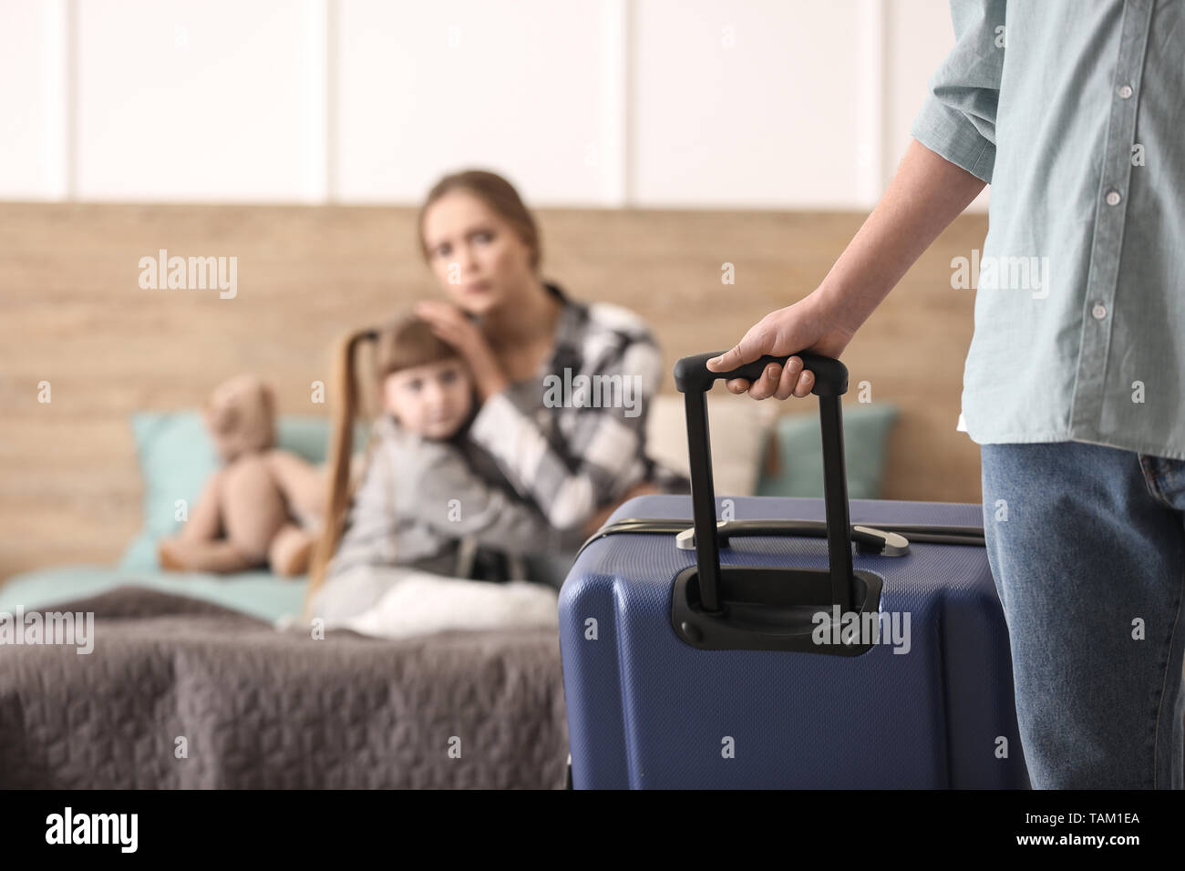 Man with suitcase leaving his family Stock Photo - Alamy