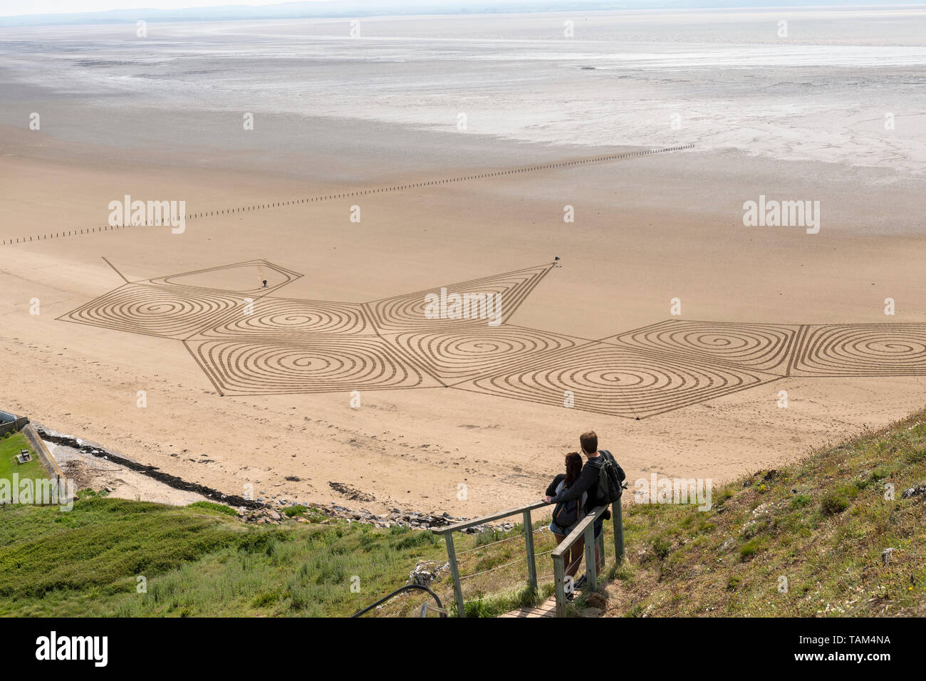 Couple watching sand sculpturer at work - Brean Down, Somerset, UK Stock Photo