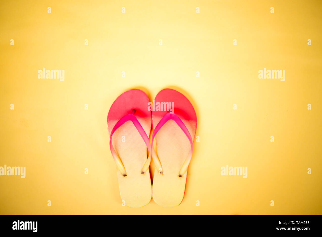 Coral pink flip flops on yellow background with copy space. Flat lay ...