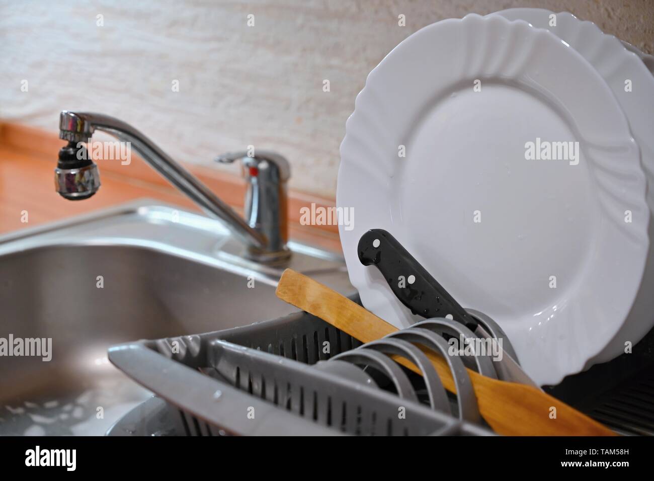 Dishes in drip tray. Clean washed dishes in the kitchen. Stock Photo