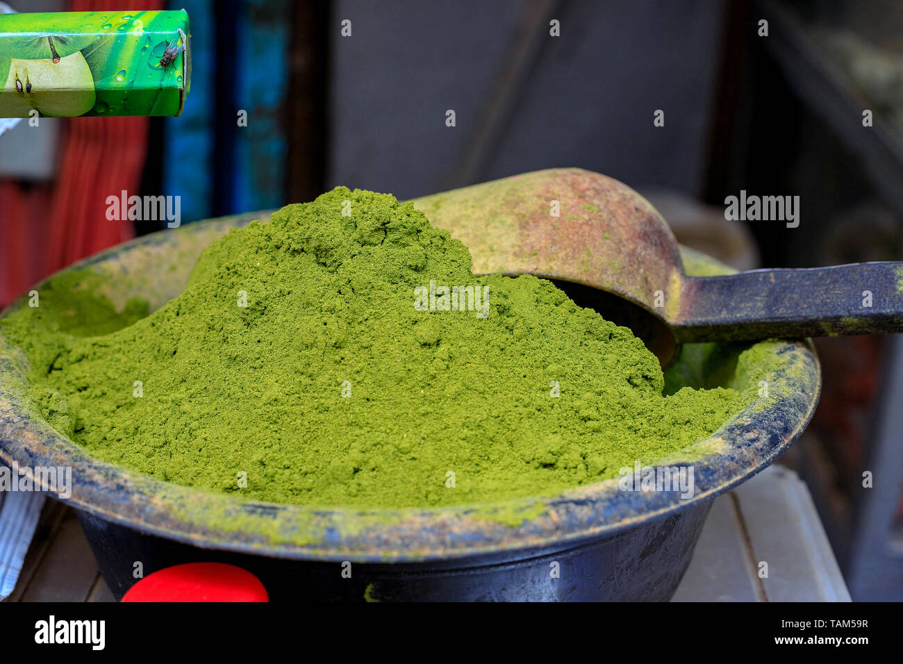 A heap of light green henna powder in a market stall in Meknès, Morocco