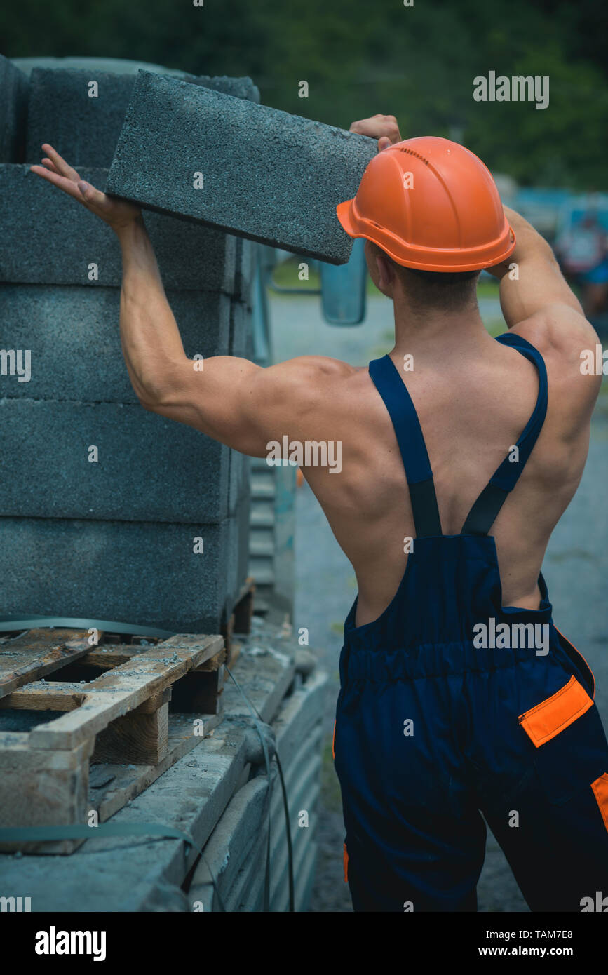 Builder concept. Builder unload truck. Builder in working uniform