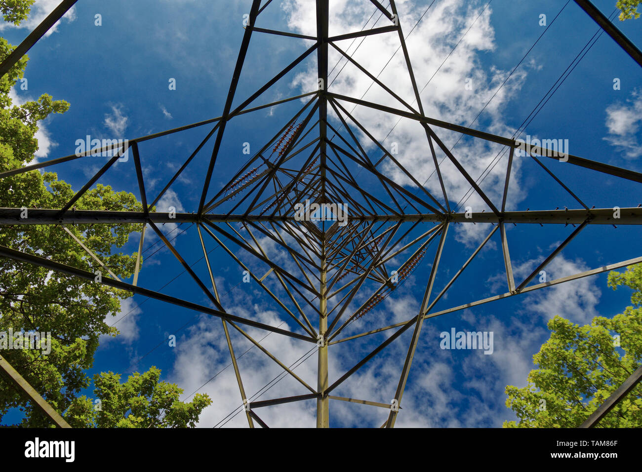 Looking up from directly underneath an electricity pylon or transmission tower Stock Photo