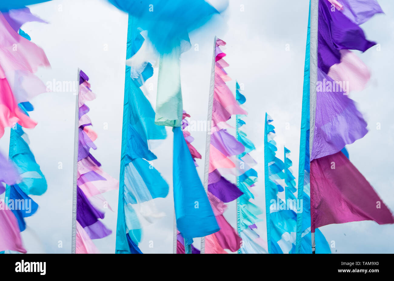 Pastel coloured festival flags. Tall poles with pink, turquoise and white flags at the River Cottage Food Fair, 2019 Stock Photo