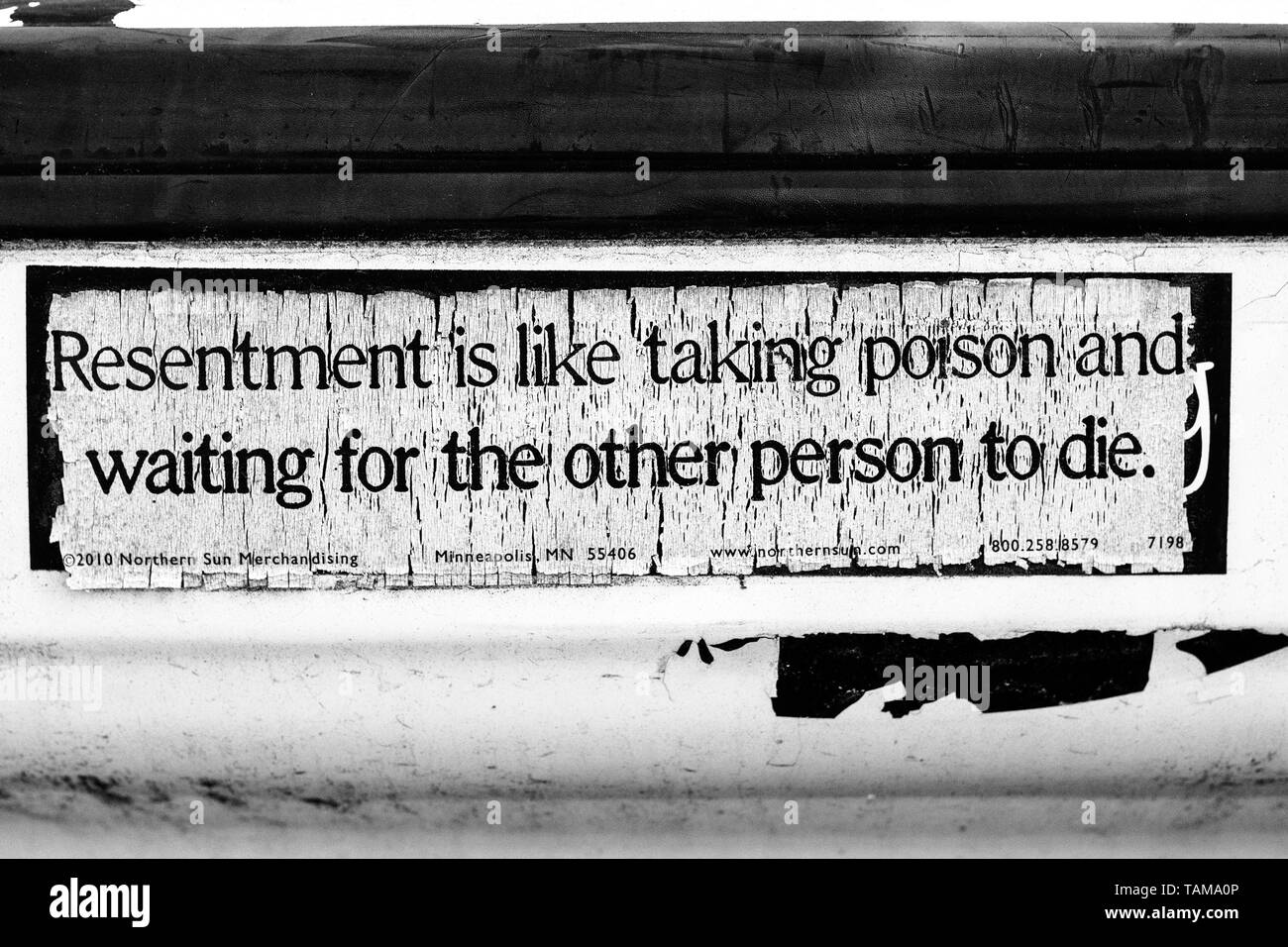 An old bumper sticker on a car reads: 'Resentment is like taking poison and waiting for the other person to die.' Stock Photo