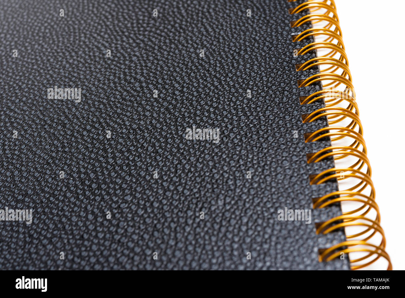 Black faux leather textured notebook cover in a yellowed metal ring