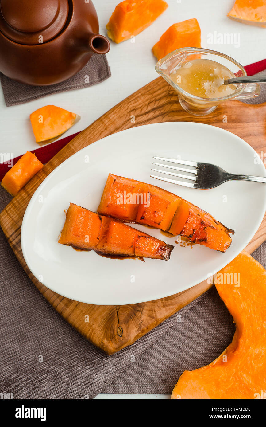 Baked pumpkin with honey and olive oil. Cafe menu on a wooden