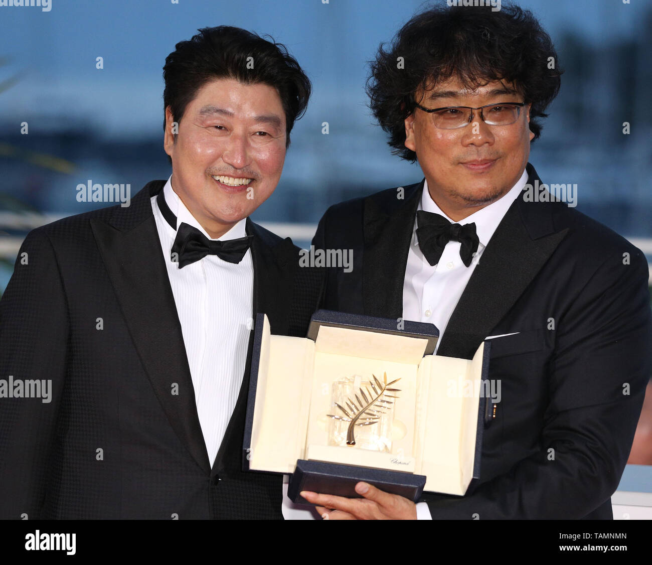 Cannes, France. 25th May, 2019. South Korean director Bong Joon-Ho (R), winner of the Palme d'Or award for the film 'Parasite' poses with actor Song Kang-ho during a photocall at the 72nd Cannes Film Festival in Cannes, France, on May 25, 2019. The curtain of the 72nd edition of the Cannes Film Festival fell on Saturday evening, with South Korean movie 'Parasite' winning this year's most prestigious award, the Palme d'Or. Credit: Gao Jing/Xinhua/Alamy Live News Stock Photo