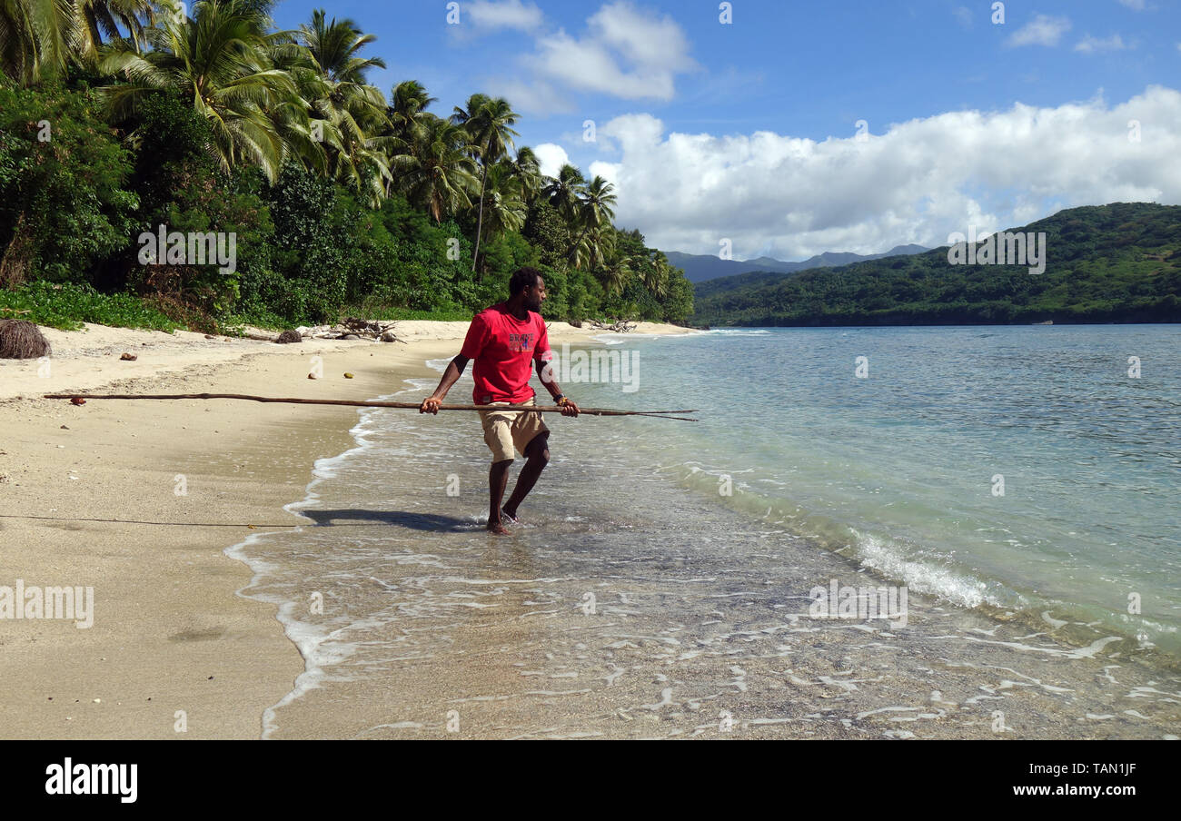 Local man using traditional spear to hunt fish in shallows, near Port Resolution, Tanna, Vanuatu. No MR Stock Photo