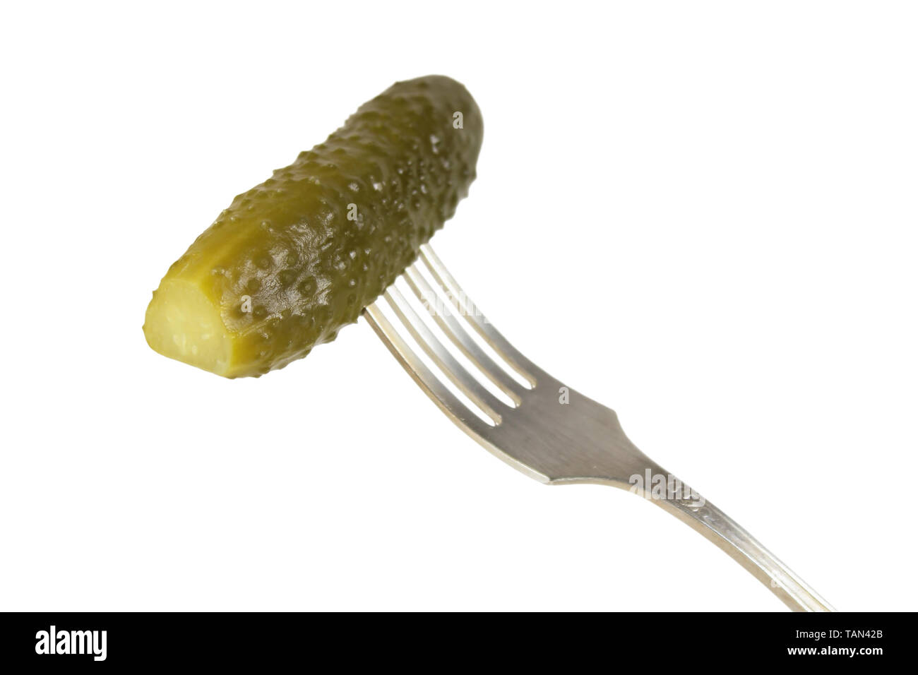 Pickled cucumber on a fork isolated on white Stock Photo