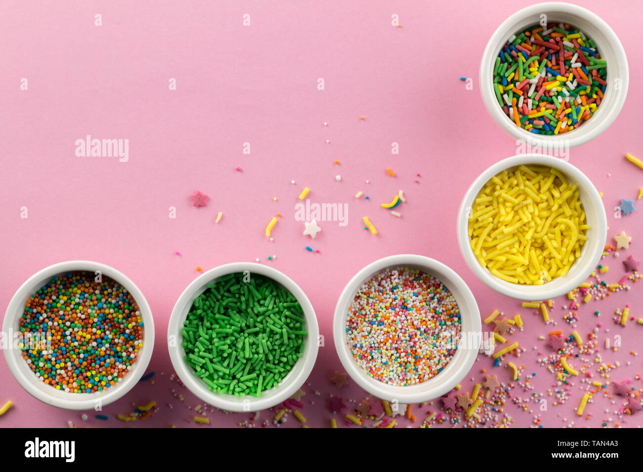 Colourful sprinkles bowls on pink hires stock photography and images