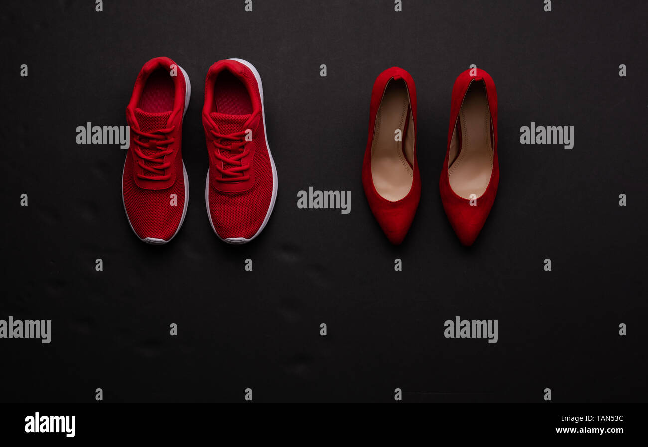 A studio shot of pair of running vs high heel shoes on black background. Flat lay. Stock Photo