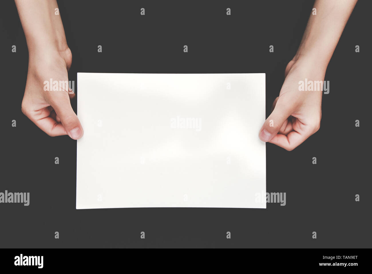 hands holding blank copy space letter on black background. Stock Photo