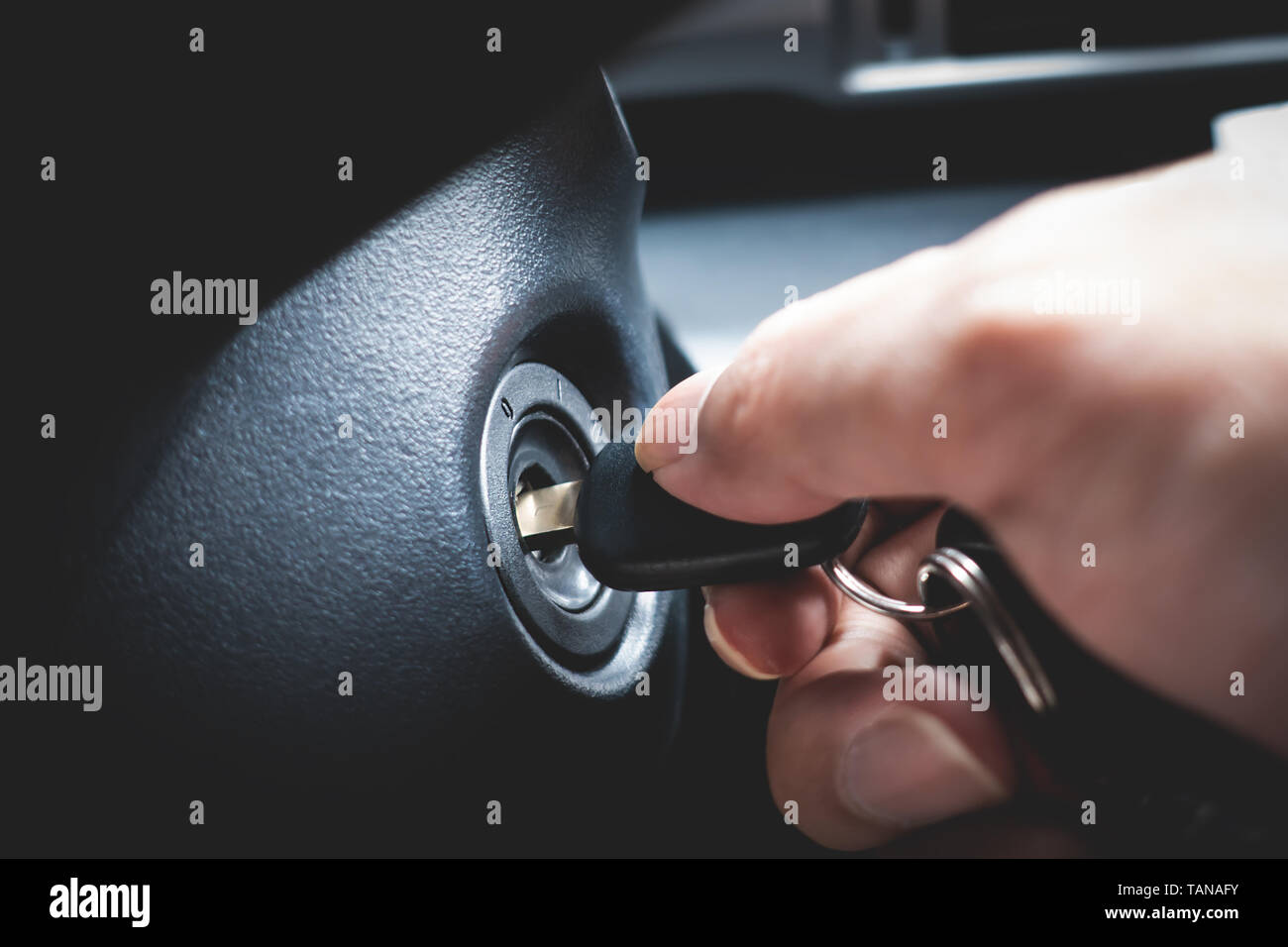 Hand turning car key in the key hole to start the car engine Stock