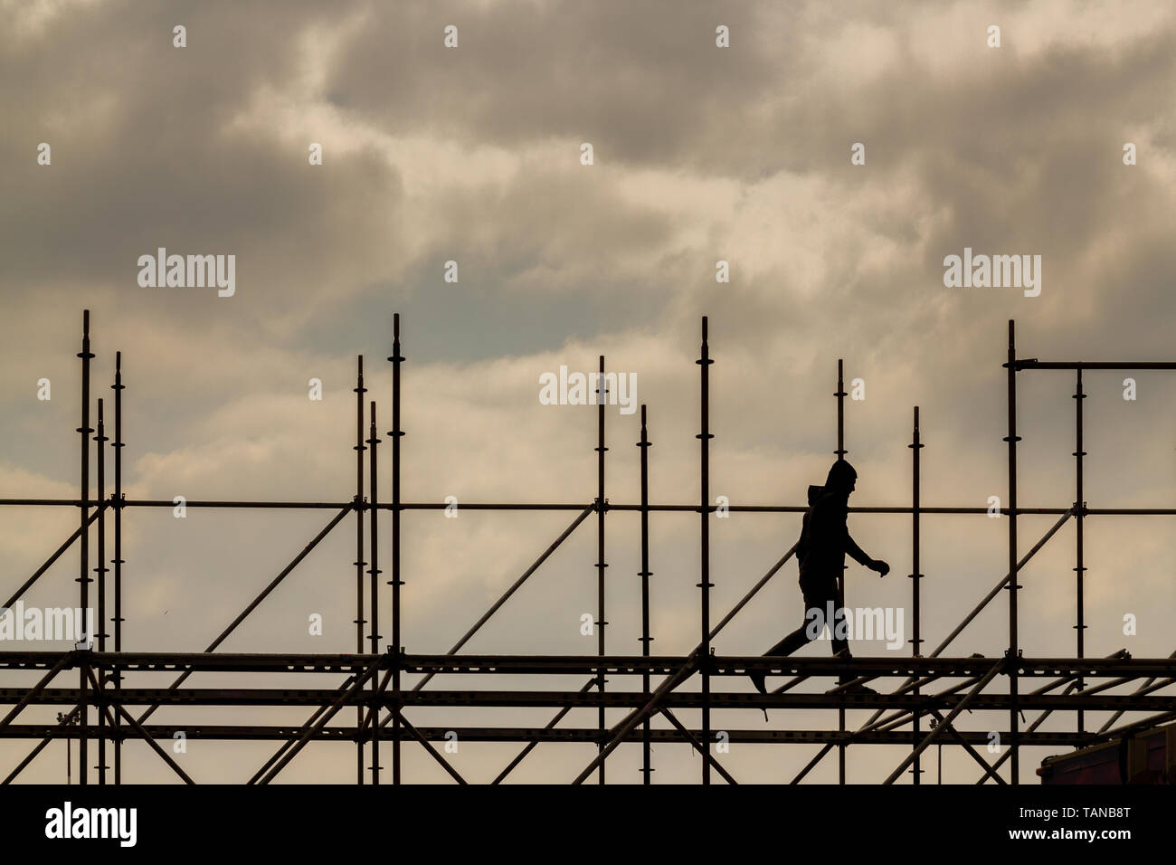 Construction workers silhouette working on iron platform sky background Stock Photo