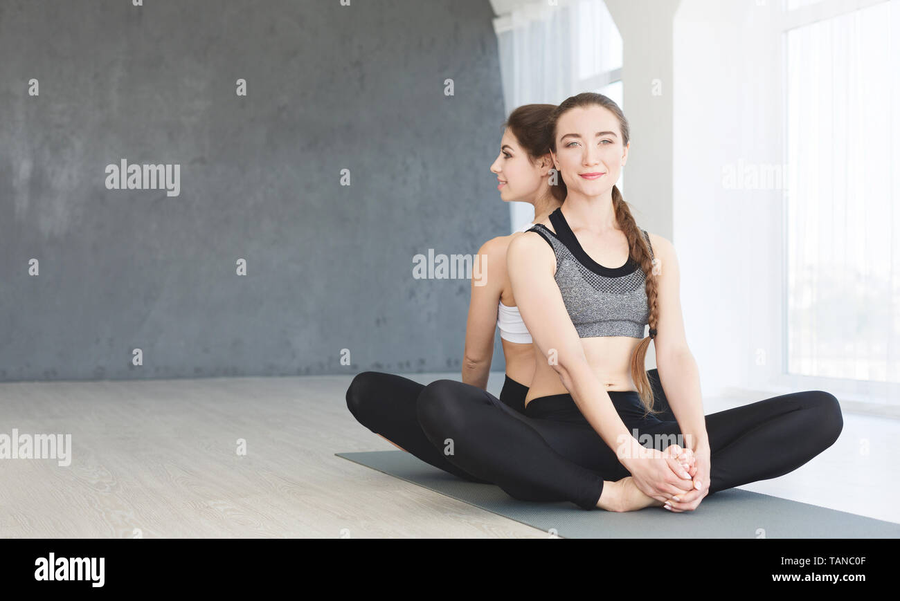 Two young girls working out and sitting in butterfly pose Stock Photo