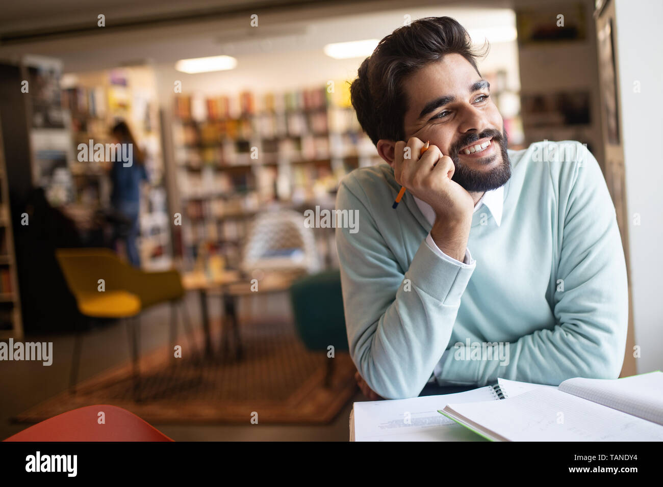 Smiling male student working and learning in a library Stock Photo