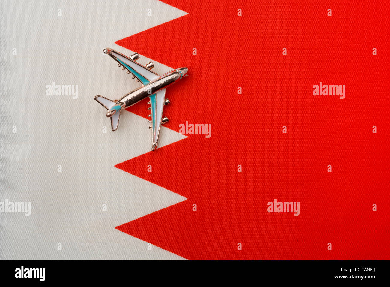 Plane over the flag of Bahrain the concept of travel and tourism. Toy plane on the flag in the background. Stock Photo