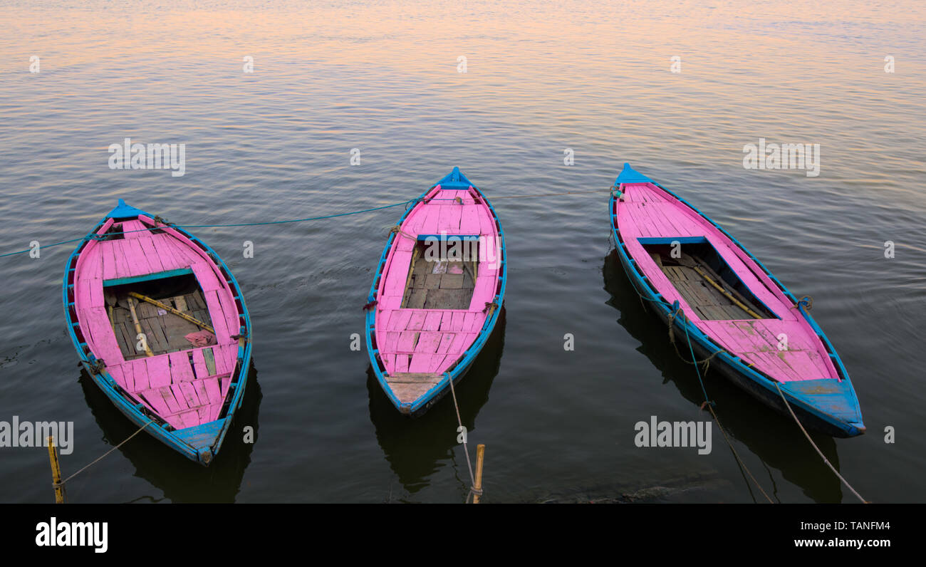 Pink Rowboat Pink rowboats at sunset on the Ganges River, Varanasi India Stock Photo ...