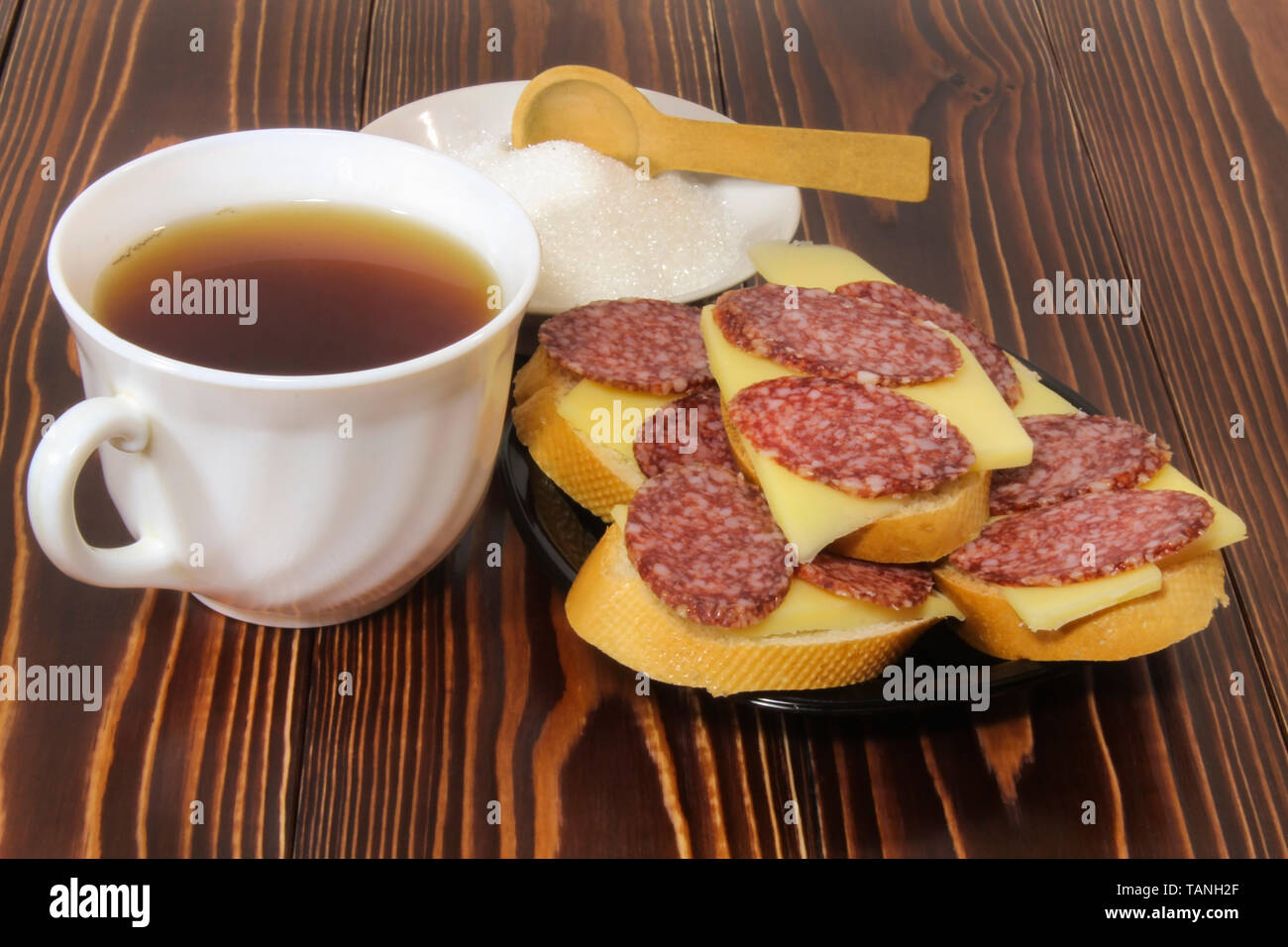 Sandwiches with cheese and smoked sausage, and tea Stock Photo