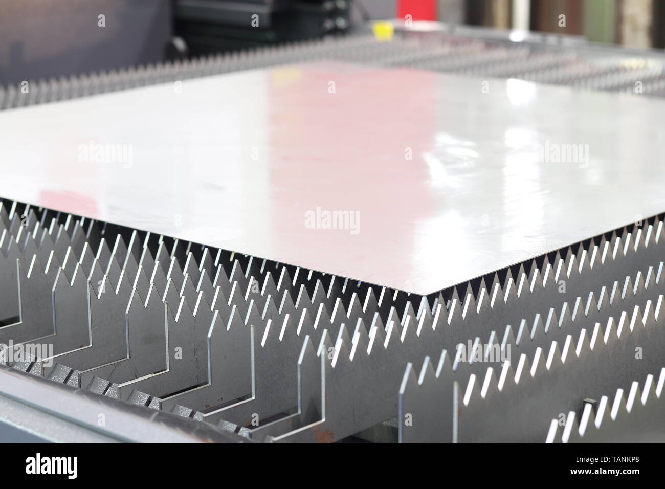 A thin steel sheet locate on laser cutting machine table Stock Photo