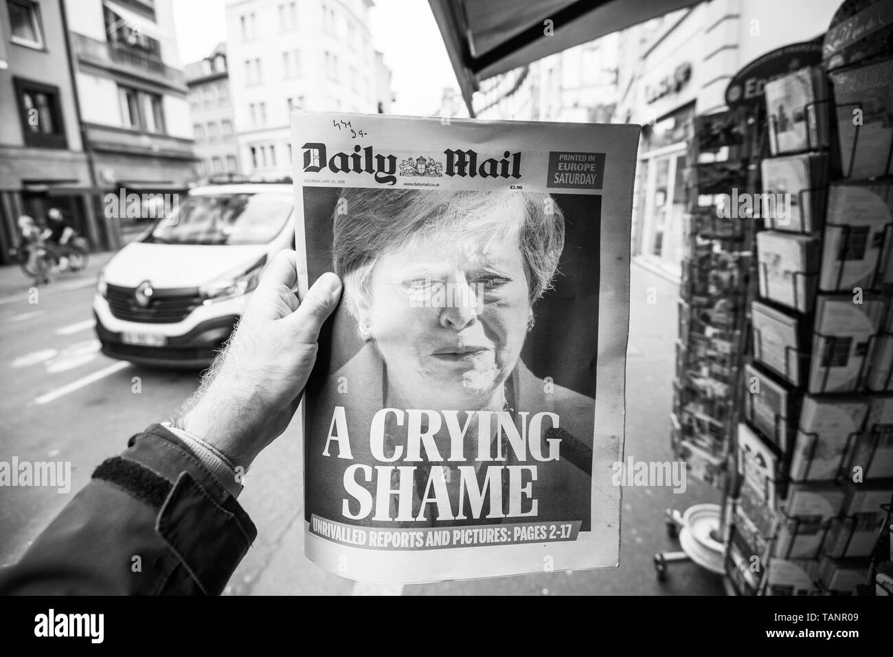 Strasbourg, France - May 27, 2019: Man holding buying newspaper front page on street press kiosk newsstand with the Theresa May crying announcing resignation - black and white Stock Photo