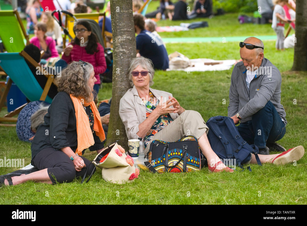 Visitors sat on grass chatting at Hay Festival Hay-on-Wye Powys Wales UK Stock Photo