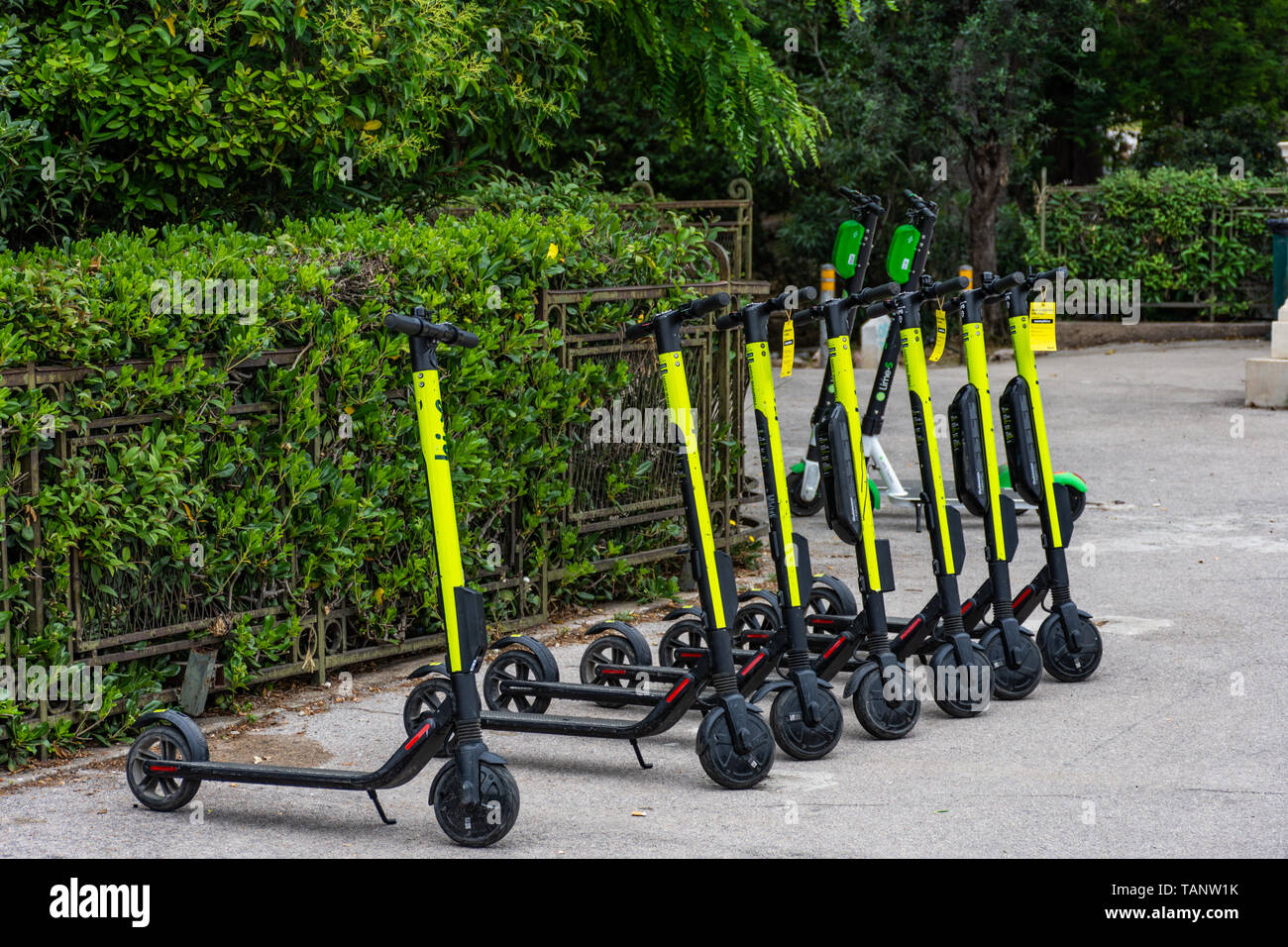 Electric scooters parked in sidewalk in downtown Athens, Greece Stock