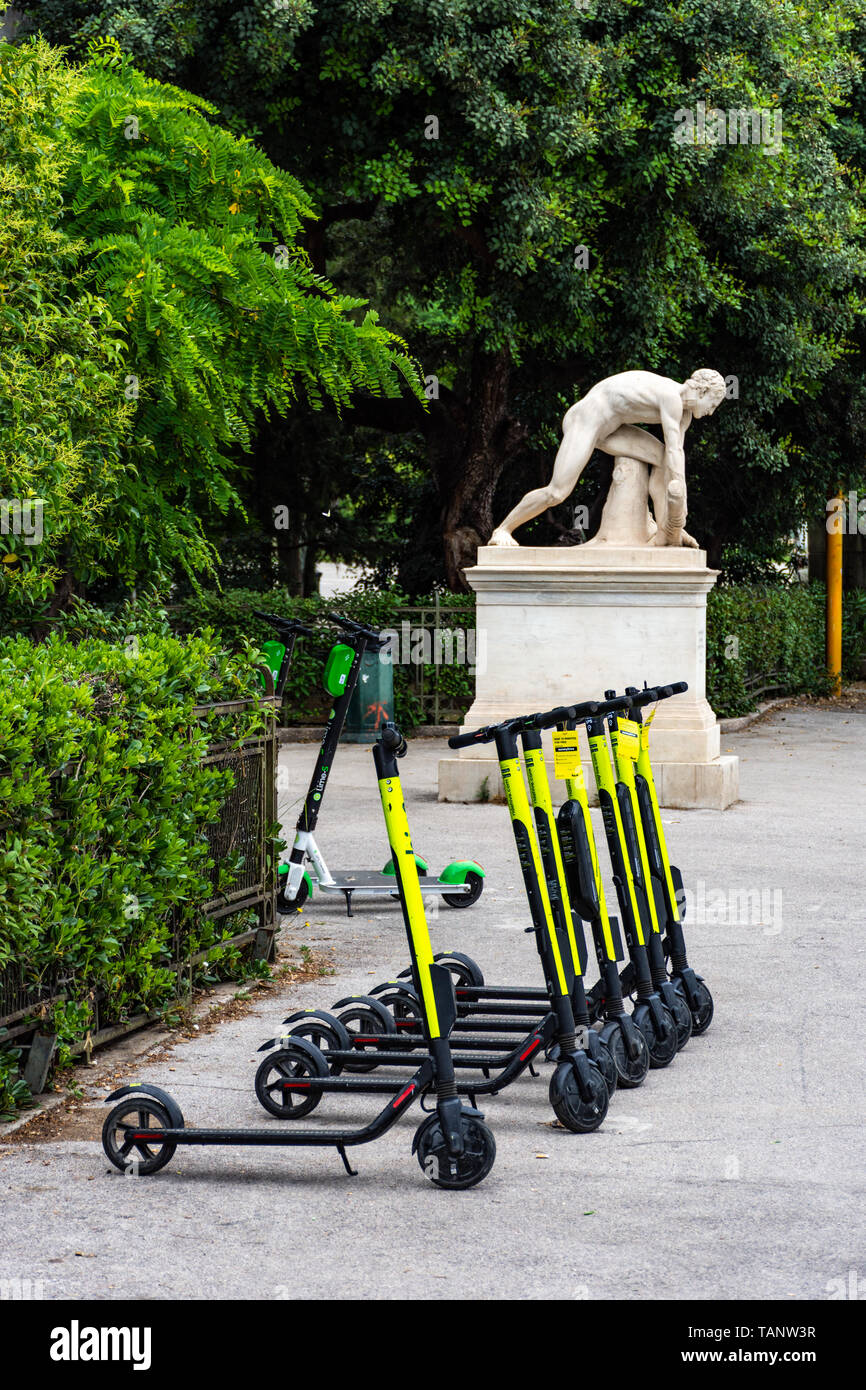 Electric scooters parked in sidewalk in downtown Athens, Greece Stock