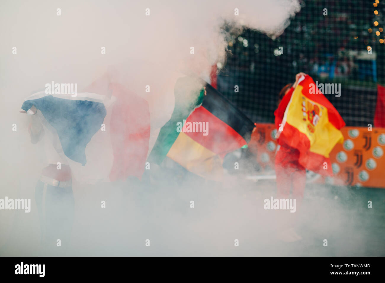 Flags Germany, Spain, France during a sports soccer match at a stadium in smoke Stock Photo