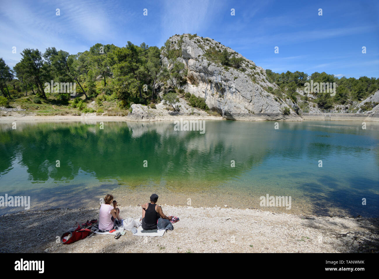 A Couple Picnicking at Peiroou Lake, Lac de Peirou, or Glanum Barrage in the Alpilles Hills near Glanum, Saint Remy-de-Provence Provence France Stock Photo