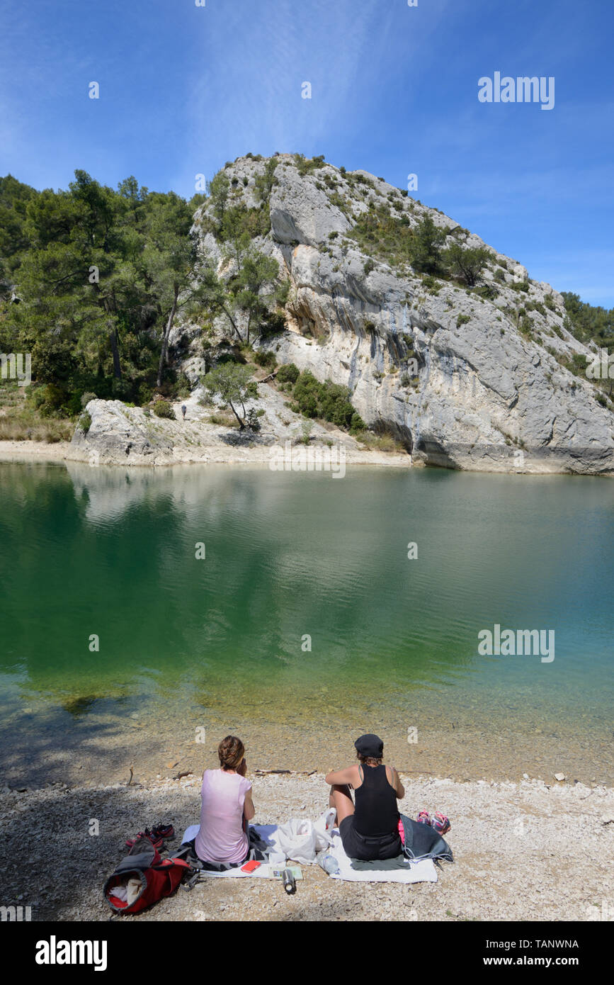 A Couple Picnicking at Peiroou Lake, Lac de Peirou, or Glanum Barrage in the Alpilles Hills near Glanum, Saint Remy-de-Provence Provence France Stock Photo