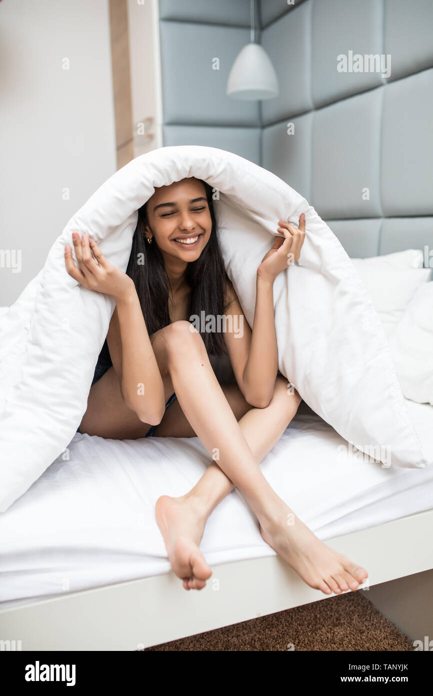 Young woman resting under a duvet in her bed Stock Photo