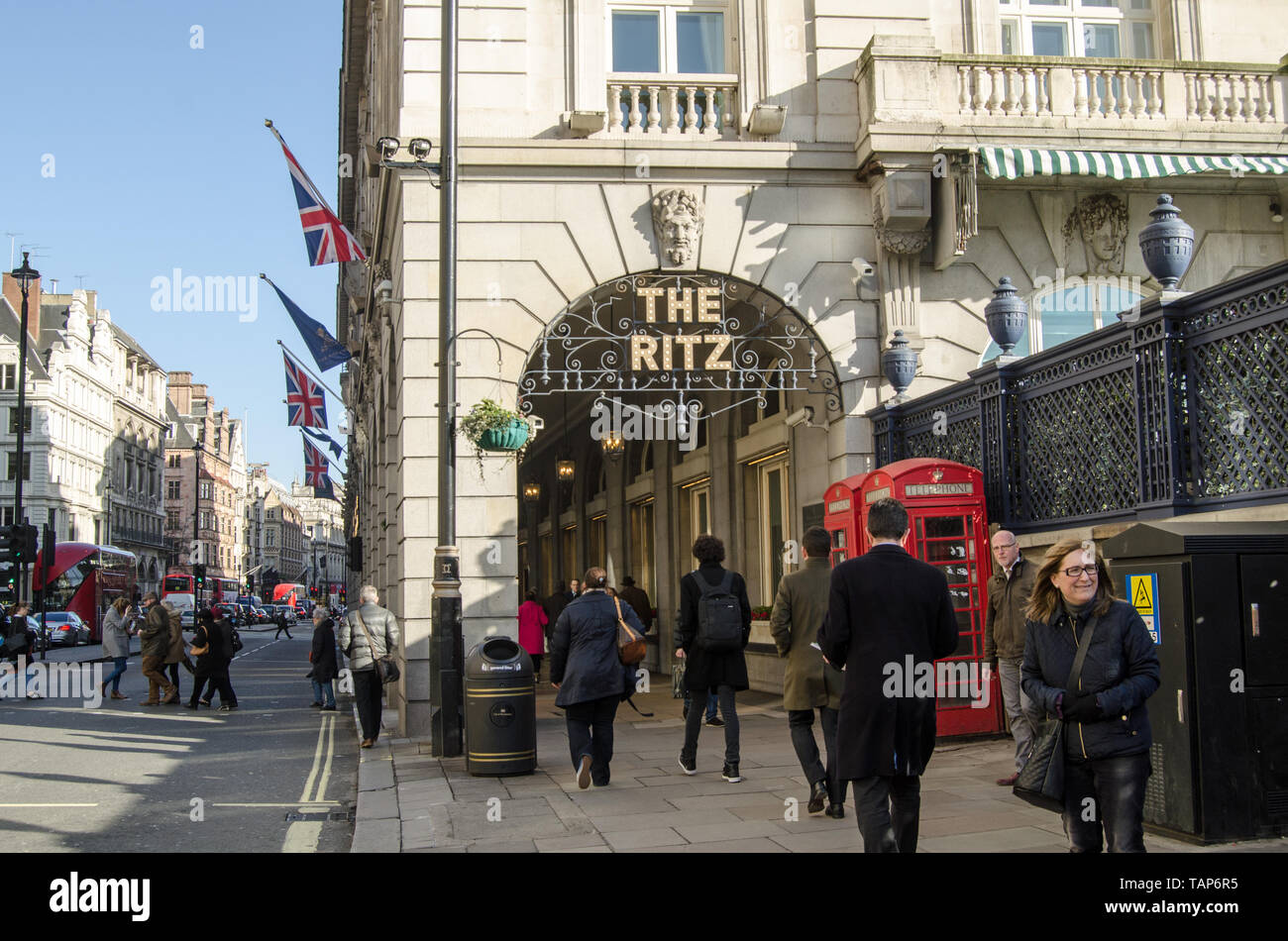 LONDON, UK - JANUARY 28, 2016:  Pedestrians and traffic at the Ritz Hotel arcade in Piccadilly, London on a sunny winter afternoon in central London. Stock Photo
