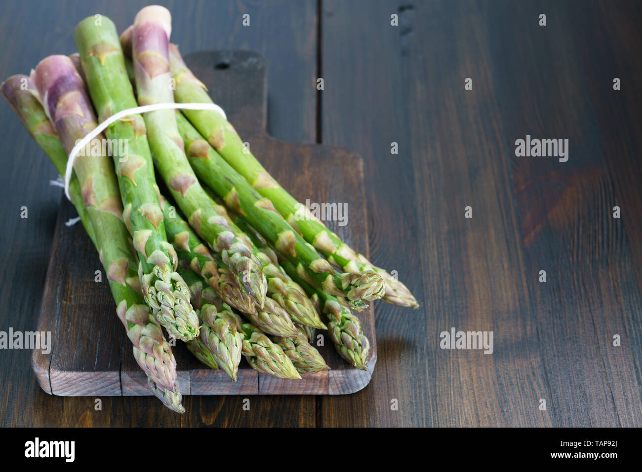1 lb/0.5 kg of fresh organic asparagus on a wooden table. High resolution Stock Photo
