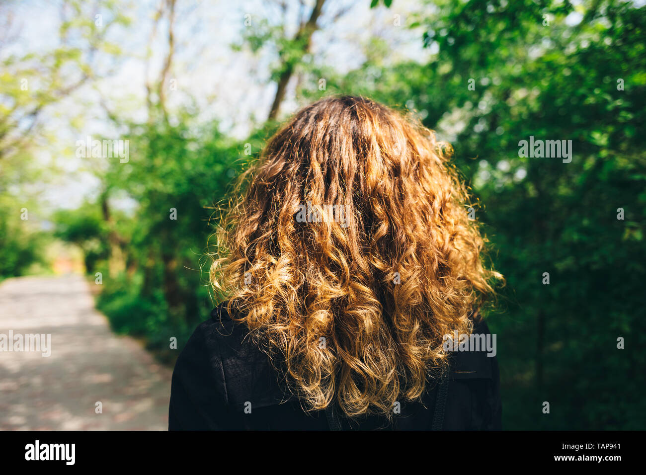 Rear View Young Woman With Thick Natural Curly Hair Strolls