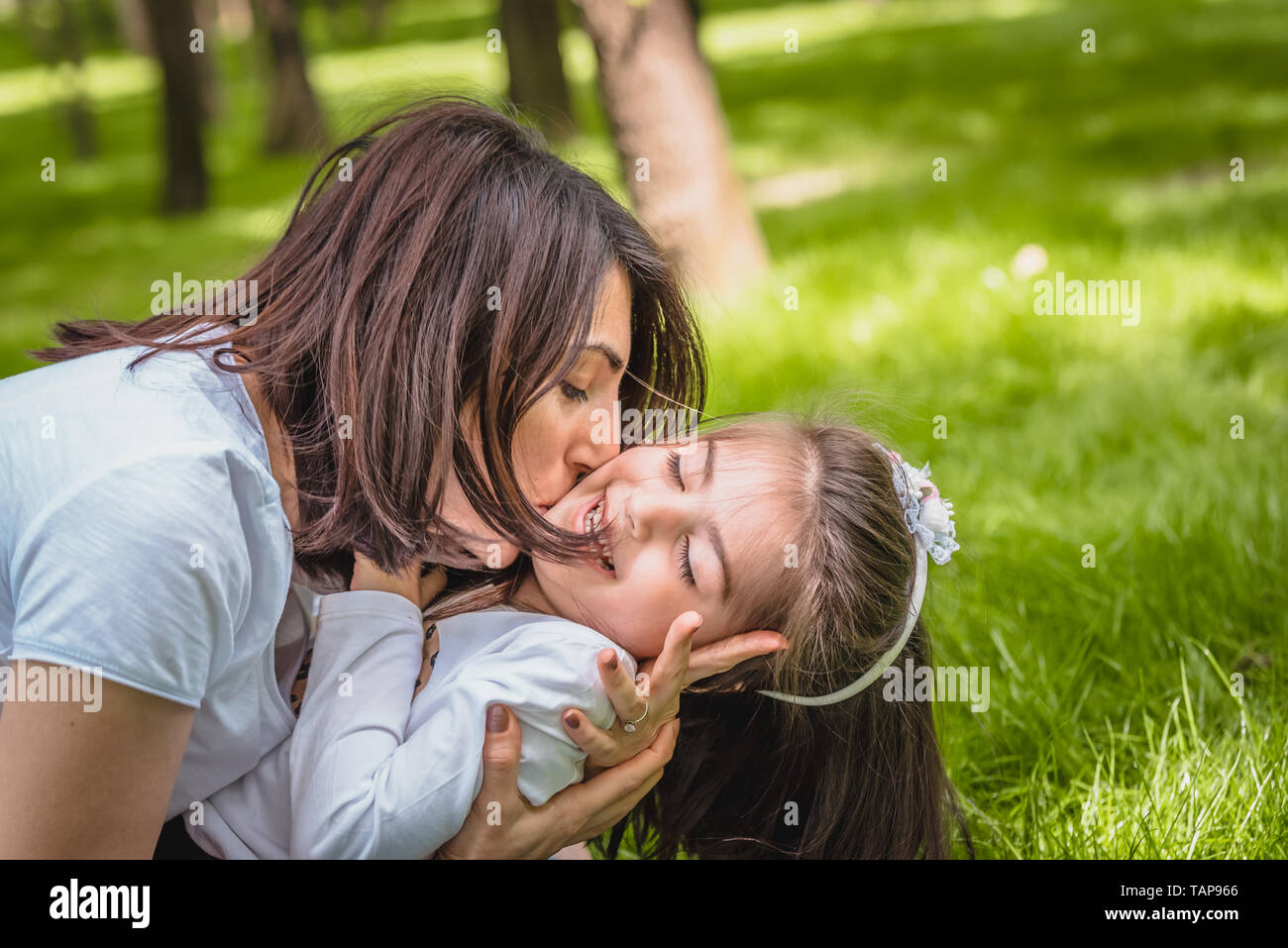 Young mom hugs and kisses her daughter showing love and support, caring  young mother embrace girl.Happy mother hugging her daughter with love and  natu Stock Photo - Alamy