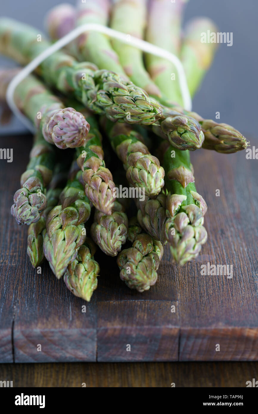 1 lb/0.5 kg of fresh organic asparagus on a wooden table. High resolution Stock Photo