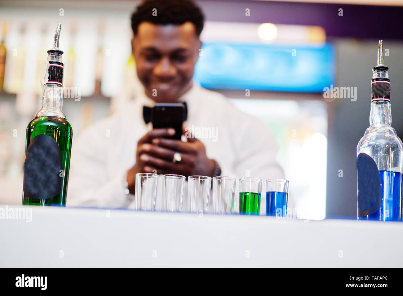 African american bartender at bar making coctails on shots and shoot ...