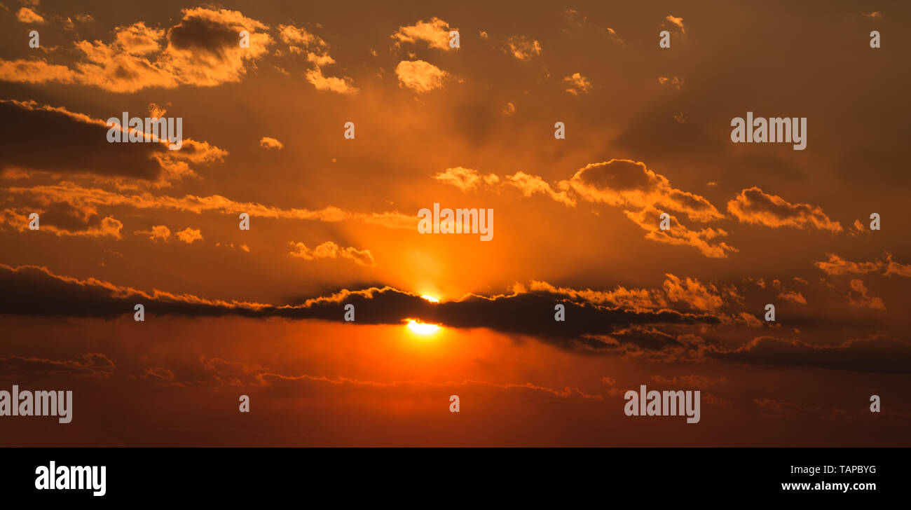 Dramatic sunset sky with orange colored clouds and sun Stock Photo - Alamy