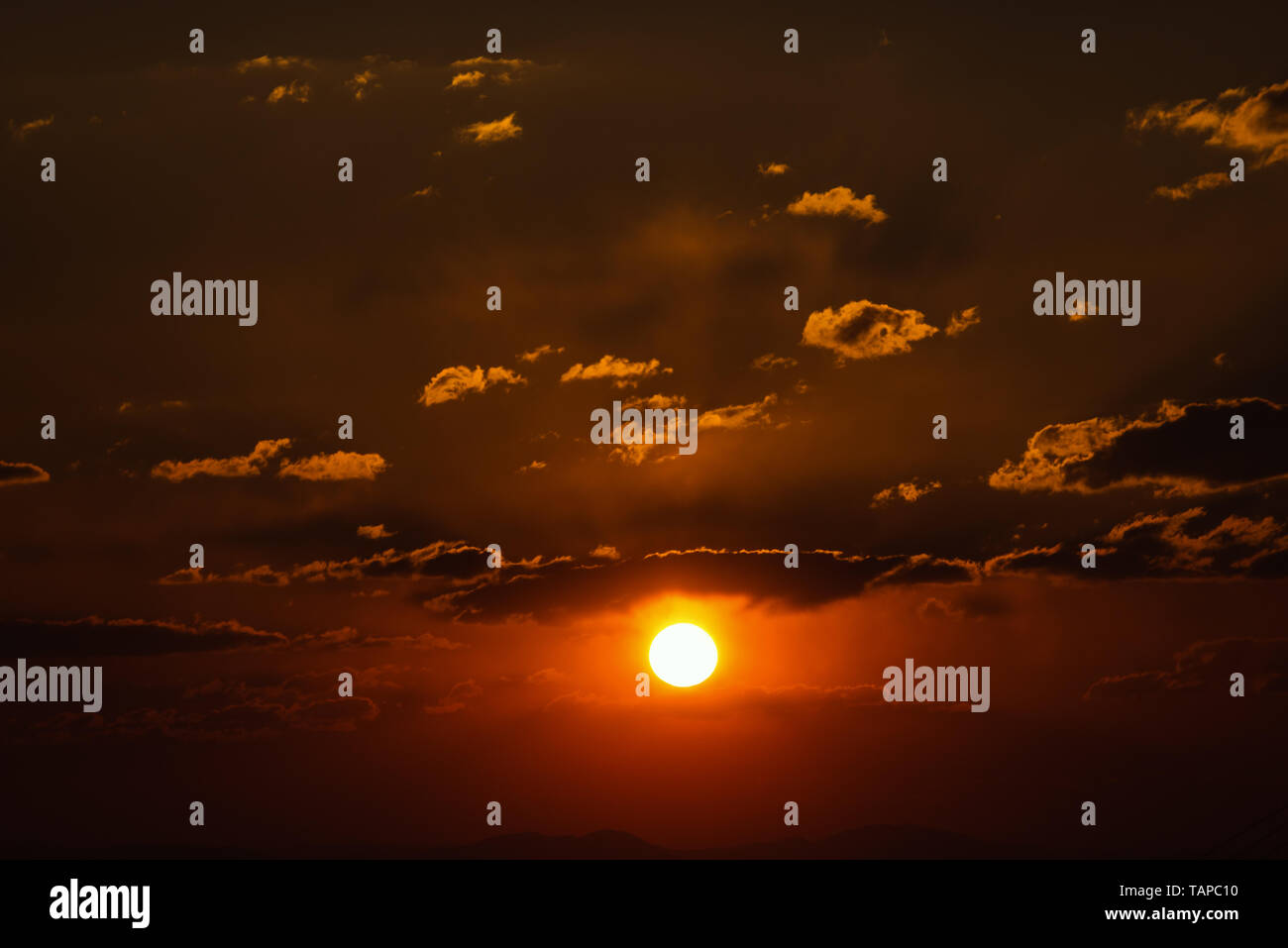 Dramatic sunset sky with orange colored clouds and sun Stock Photo - Alamy