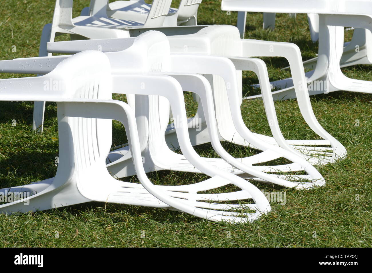 White plastic chairs lying on a meadow, Germany, Europe Stock Photo Alamy